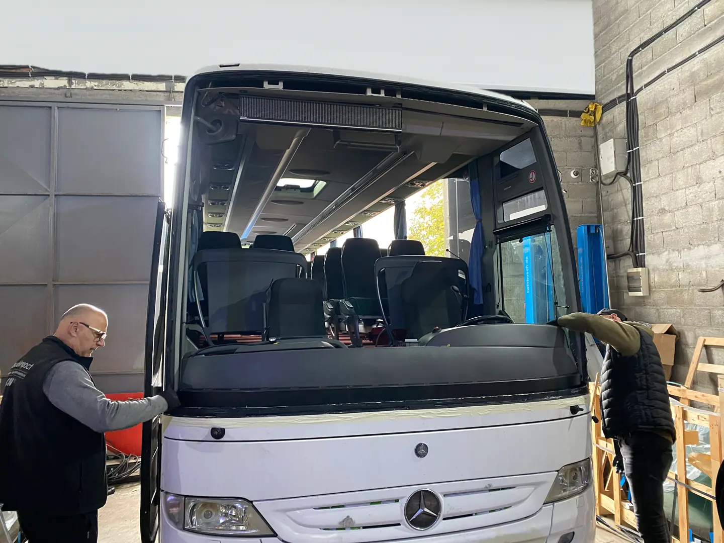 Radnici popravljaju autobus u radionici.